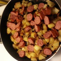 A picture of Kielbasa, potatoes and onions.