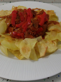 Una foto de Estofado de ternera con salsa de tomate y patatas fritas