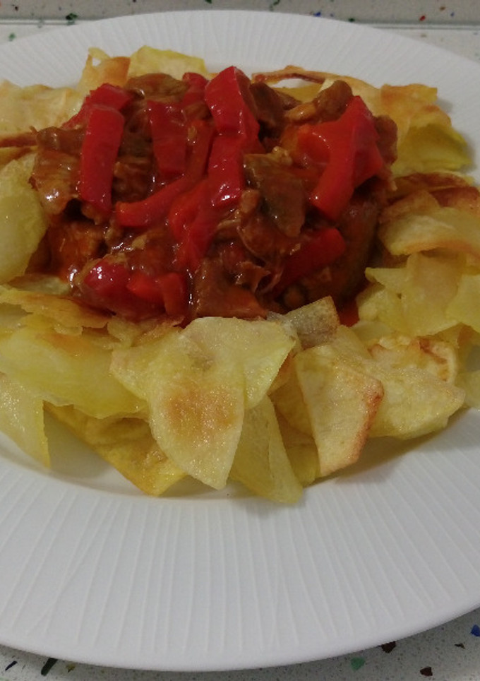 Una foto de Estofado de ternera con salsa de tomate y patatas fritas