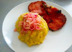 Una foto de Mangu o puré de plátanos con cebollas