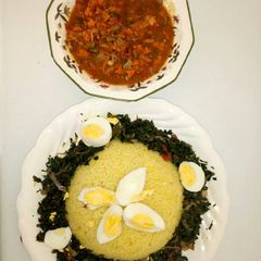 A picture of Curry rice with spinach and cArrots sauce.