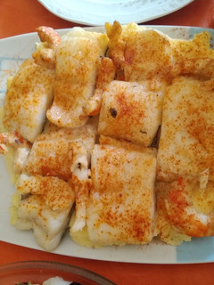 Una foto de Bacalao al vapor con langostinos y cama de patatas
