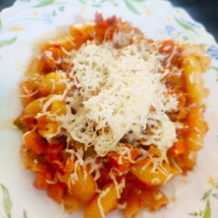 A picture of Cheesy Macaroni in tomato and cream sauce.