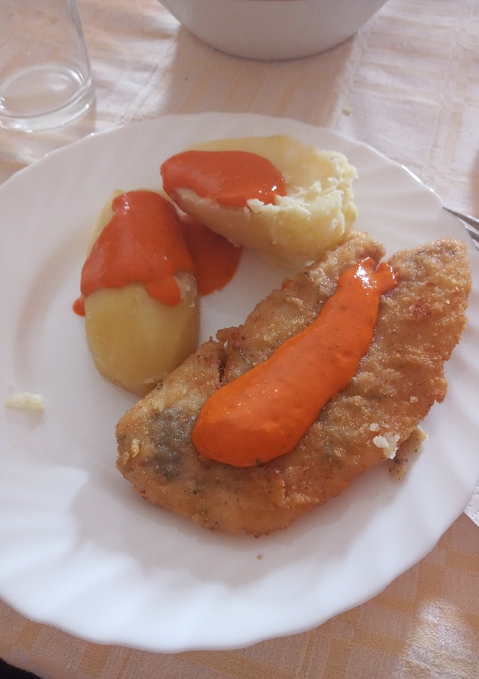 Una foto de Gallo adobado y empanado con papas cocidas y mojo de pimiento