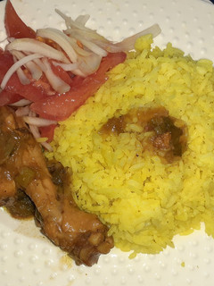Una foto de Pollo en salsa negra con arroz y ensalada de tomate y cebolla
