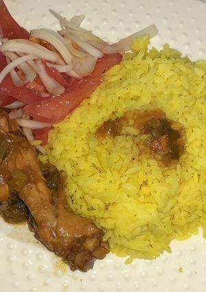 Una foto de Pollo en salsa negra con arroz y ensalada de tomate y cebolla