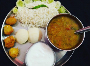 A picture of South Indian Platter Sambhar Rice Idli Vada.