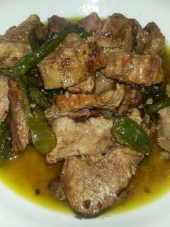 Una foto de Pluma ibérica asada con pimientos Padrón