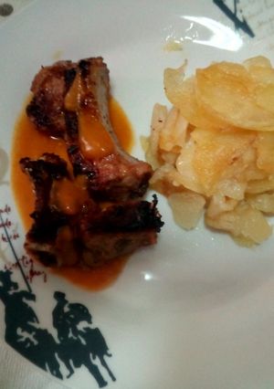 Una foto de Costillas adobadas con salsa de verduras y guarnición de patatas