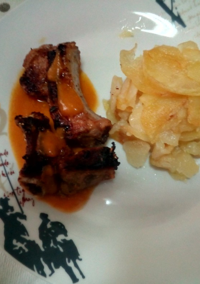 Una foto de Costillas adobadas con salsa de verduras y guarnición de patatas