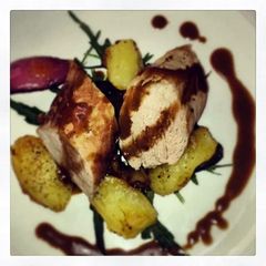 A picture of Pork fillet with crushed potatoes and balsamic dressing.