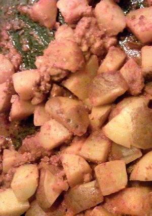 A picture of papas y longanesa con salsa.