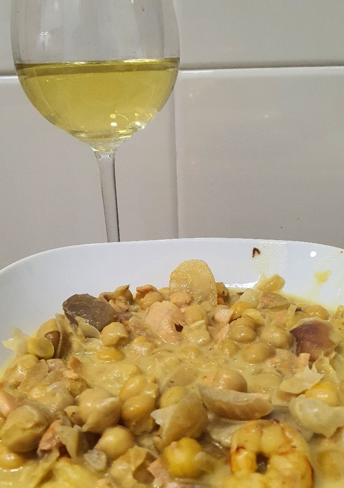 Una foto de Garbanzos al curry con gambones y salmón sobre leche de coco
