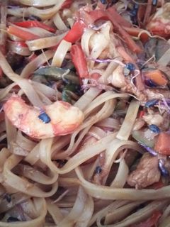 Una foto de Wok de tallarines de arroz con gambones, secreto Ibérico y verduritas a la mantequilla