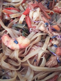 Una foto de Wok de tallarines de arroz con gambones, secreto Ibérico y verduritas a la mantequilla