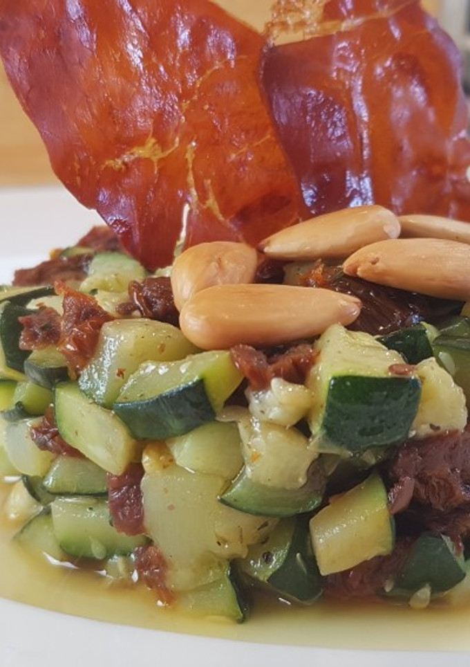 Una foto de Timbal de calabacín con tomates secos y crujiente de jamón