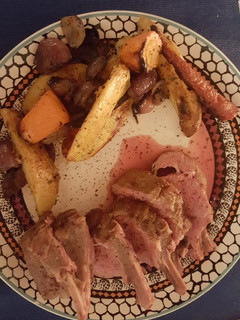 A picture of Rack of Lamb with roasted veggies.