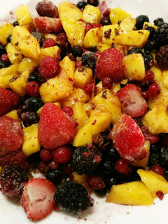 Una foto de Macedonia de mango y frutas del bosque