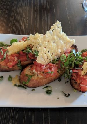 A picture of Bruschetta with asiago chips.