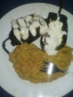 Una foto de Chiles poblanos rellenos y arroz con salsa poblana