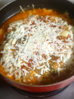 A picture of Baked spinach paneer cannelloni with tomato sauce and veggies.