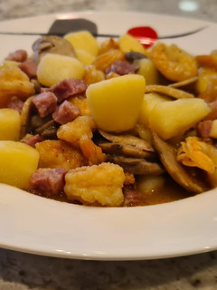 Una foto de Patatas en salsa con langostinos y champiñones
