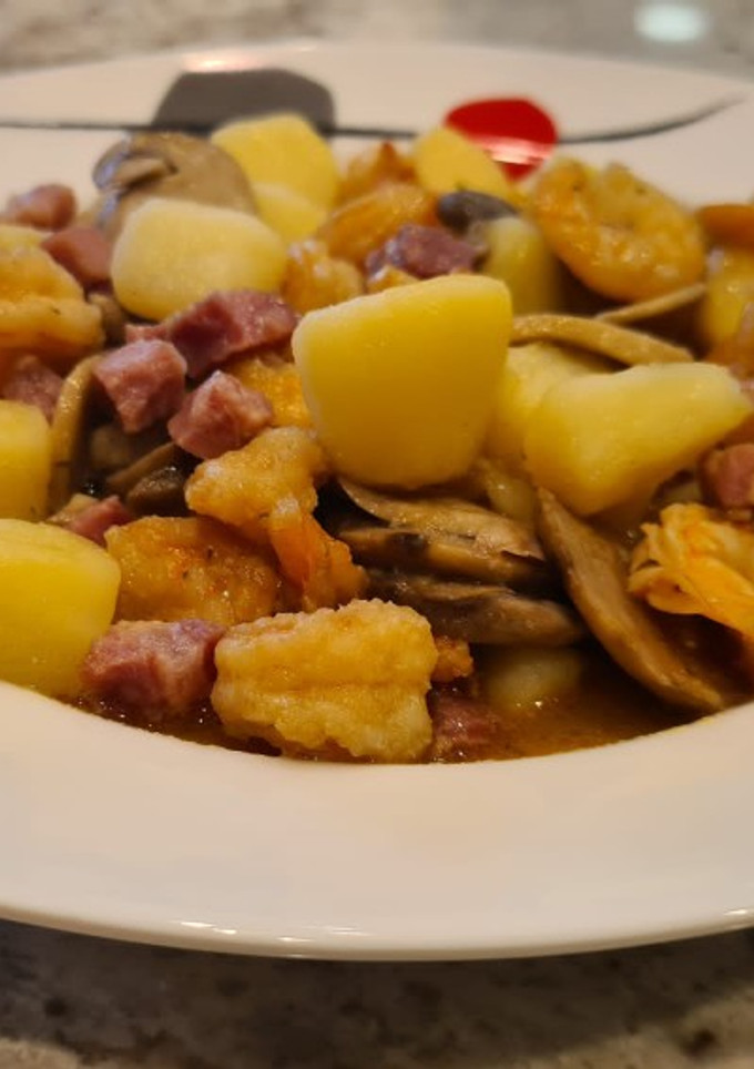 Una foto de Patatas en salsa con langostinos y champiñones