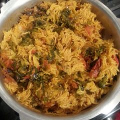 A picture of Tomato rice with dill and cilantro.