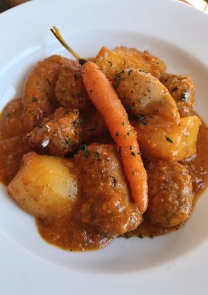 Una foto de Albóndigas y butifarra con chipirones, patatas y zanahorias baby