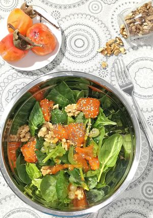 Una foto de Ensalada de espinacas con caqui, nueces y uva