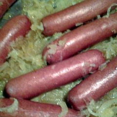 A picture of hotdogs fried in sauerkraut.