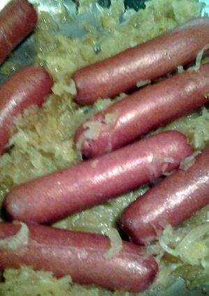 A picture of hotdogs fried in sauerkraut.