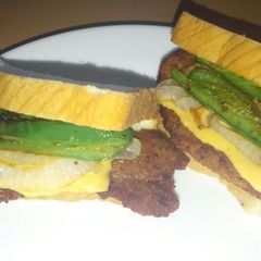 A picture of Fried pork chop jalapeno onion and cheese sandwich.