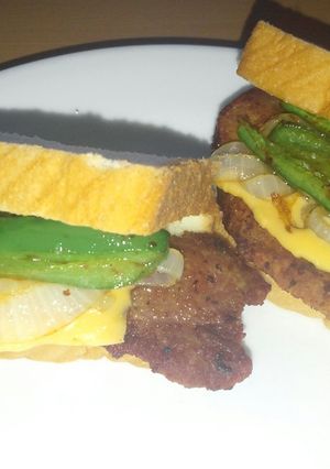 A picture of Fried pork chop jalapeno onion and cheese sandwich.