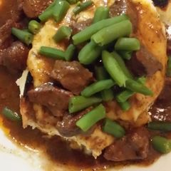 A picture of Patty's Slow cooked beef cubes on top of mountain of fluffy mash.