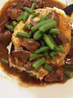A picture of Patty's Slow cooked beef cubes on top of mountain of fluffy mash.