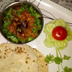 A picture of Achari baingan bharta with chapati and salad.