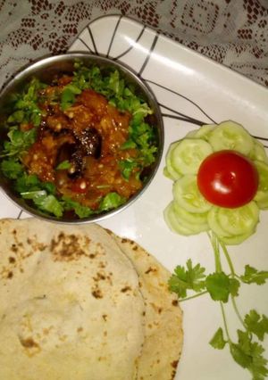 A picture of Achari baingan bharta with chapati and salad.