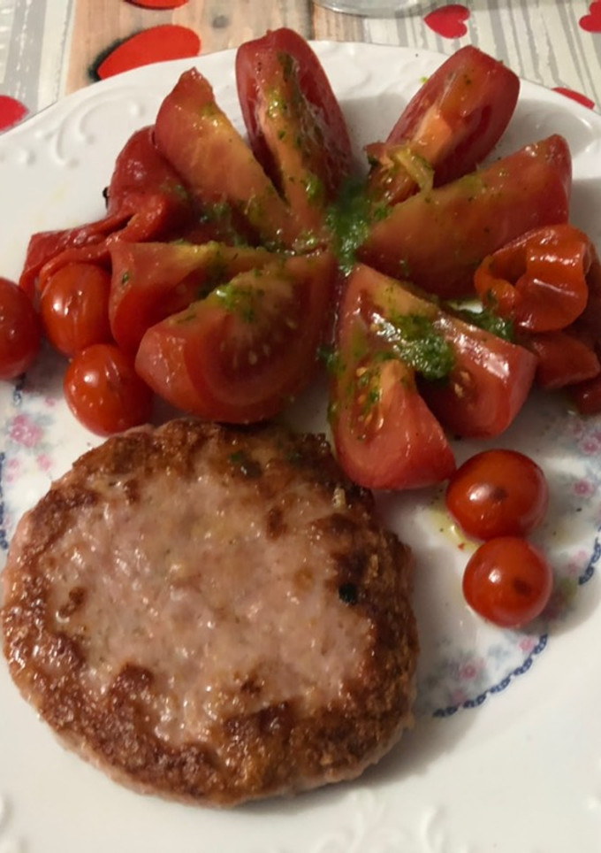 Una foto de Hamburguesa de pollo con flor de tomate y pimiento asado