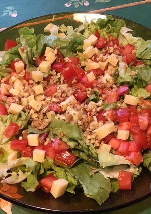 Une photo de Salade de tomates au comté et noix sur lit de feuille de chêne