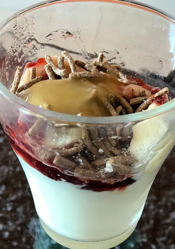 Una foto de Desayuno fresco de verano; yogurt, banana, cereal y miel