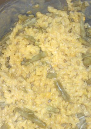 A picture of Mac n cheese with green beans.