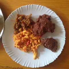 A picture of Left over beef and scrambled eggs served with brown ugali.