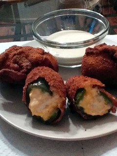 A picture of stuffed jalapenos wrapped in bacon.