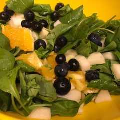 Una foto de Ensalada de rúcula, manzana, naranja, roquefort y arándanos