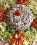 Fuente de arroz rosa y lentejas caviar con ensalada