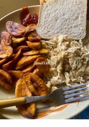 A picture of Fried plantains, scrambled eggs & bread 🍞.