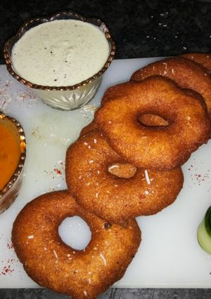 A picture of Medu vada with sambhar and coconut chutney.