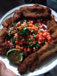 Una foto de Pescado empanizado con pico de gallo y salsa