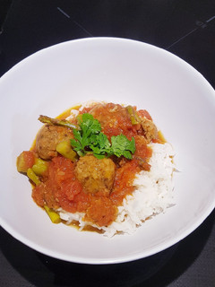 Una foto de Albondigas especiadas en salsa de tomate con espárragos